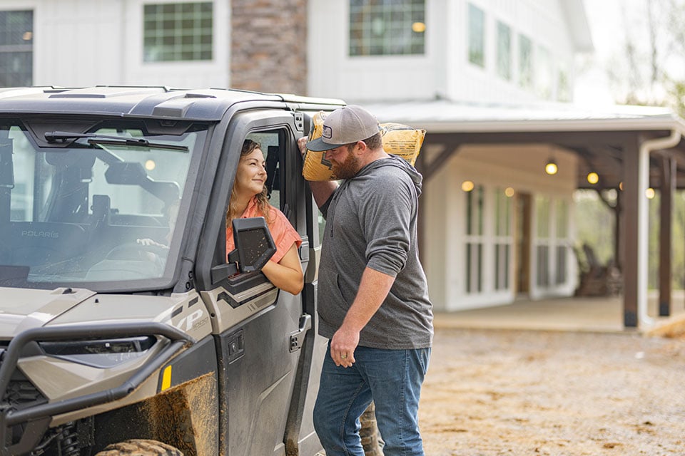 A married couple smile at each other after building a barndominium in Tennessee.