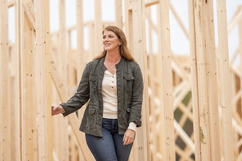 Woman walking through her building site after securing a home construction loan in Indiana.