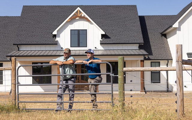 A man and his Rural 1st loan officer admiring the view from the front yard of his newly built rural home.