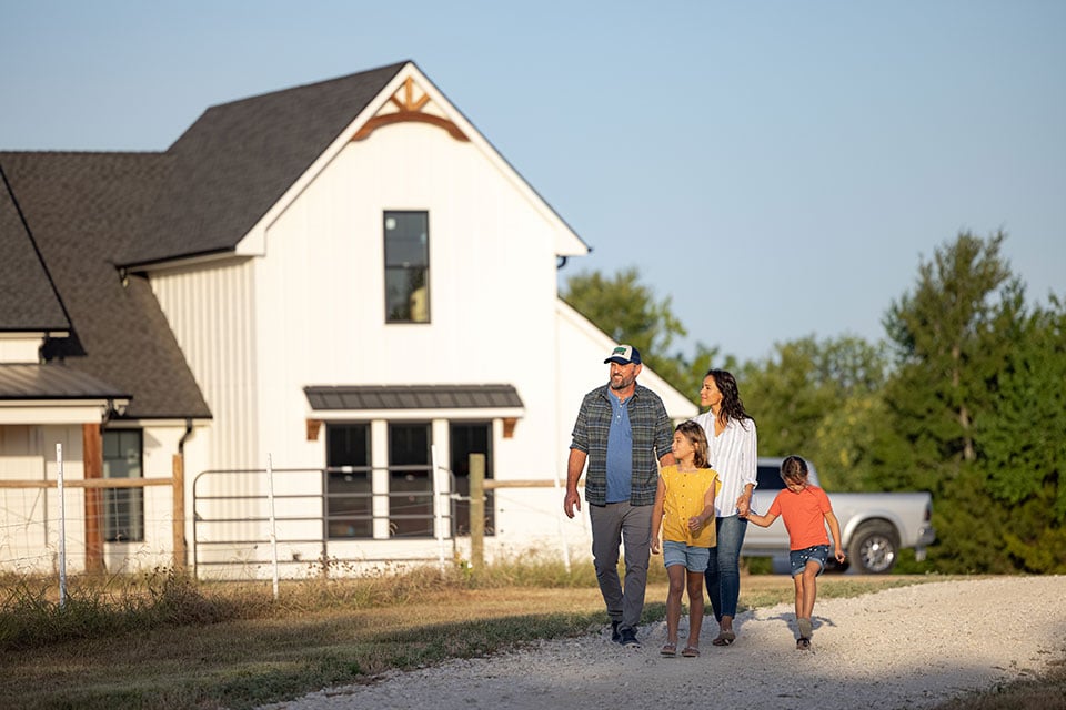 Family walking down the driveway in front of their house